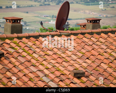 Sat-TV Gerichte stehen im Kontrast zu älteren Häusern in Cortona, Italien Stockfoto