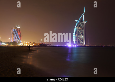 Strand von Jumeirah Burj Al Arab und Jumeirah Beach Hotel, nachts beleuchtet. Dubai, Vereinigte Arabische Emirate. Stockfoto