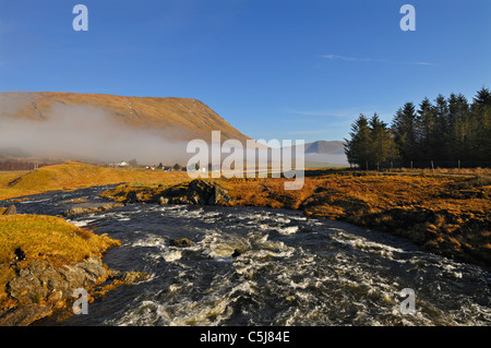 Der Fluss Lyon stürzt in Richtung der entfernten Township Cashlie in abgelegenen Glen Lyon mit einem Stand von Nadelbäumen und einer bank Stockfoto