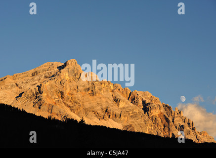 Mondaufgang und Alpenglühen auf den westlichen Klippen der Fanes NP gesehen aus Badia Dorf der Dolomiten Region Norditaliens. Stockfoto