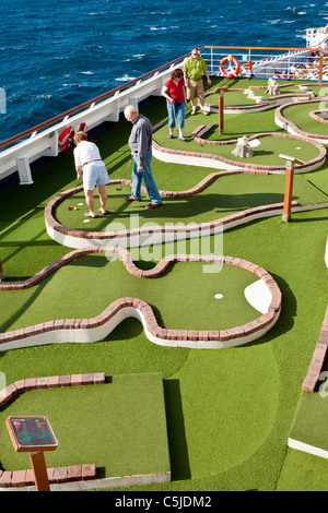 Kreuzfahrt-Passagiere spielen Minigolf auf dem Deck des Kreuzfahrtschiffes Carnival Triumph im Golf von Mexiko Stockfoto