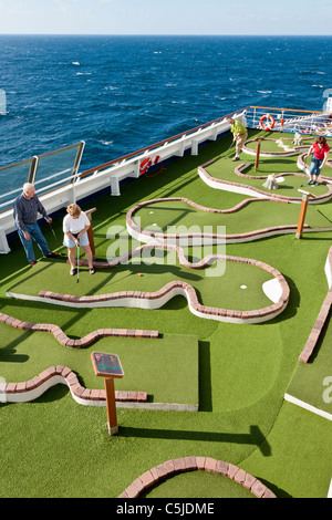 Kreuzfahrt-Passagiere spielen Minigolf auf dem Deck des Kreuzfahrtschiffes Carnival Triumph im Golf von Mexiko Stockfoto