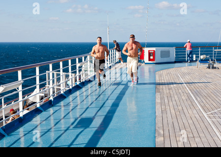 Zwei Männer laufen auf jogging-Strecke auf dem Sport Deck der Carnival Triumph Kreuzfahrtschiff im Golf von Mexiko Stockfoto
