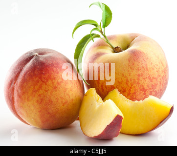 Reife Pfirsichfrucht mit Blättern und Scheiben auf weißem Hintergrund. Stockfoto