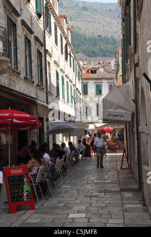 Eine schmale Straße mit Cafés und Restaurants in der Altstadt von Dubrovnik, Kroatien Stockfoto