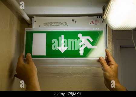 Qualifizierten Elektriker Installation Notbeleuchtung Panel auf Fluchtweg. Stockfoto