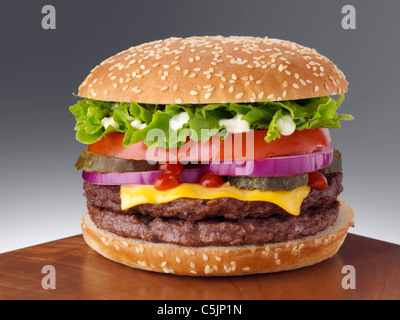 Cheeseburger mit zwei Rindfleisch Burger Salat rote Zwiebel Gherkin Mayonnaise und Tomaten ketchup Stockfoto