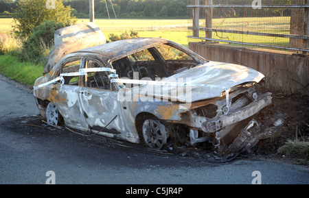 AUSGEBRANNT, GESTOHLENEN VERLASSENEN WAGEN ABGELADEN IN COUNTRY LANE, GROßBRITANNIEN Stockfoto