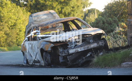 AUSGEBRANNT, GESTOHLENEN VERLASSENEN WAGEN ABGELADEN IN COUNTRY LANE, GROßBRITANNIEN Stockfoto