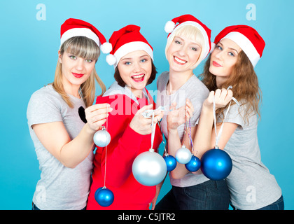 Vier glückliche Frauen mit Neujahr Kugeln lächelnd Stockfoto