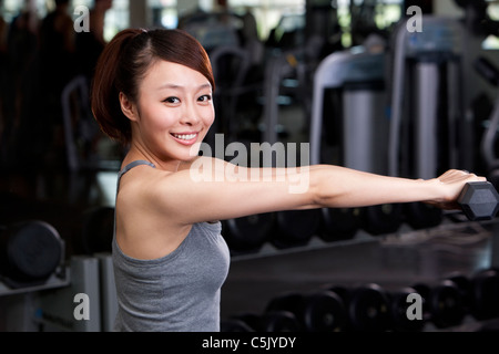 Junge Frau heben Gewichte Stockfoto