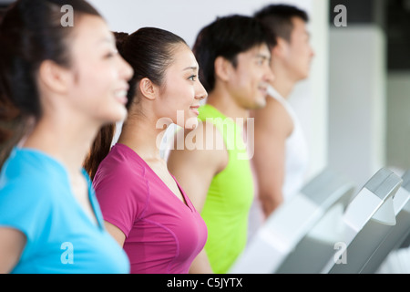 Vier Menschen laufen auf Laufbändern Stockfoto