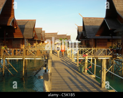 Paar mittleren Alters zu Fuß unter der Bungalows, Sipadan-Kapalai Dive Resort, Sabah, Borneo, Malaysia Stockfoto