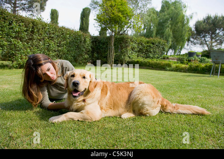 Junge Frau und Golden Retriever Hund im Garten. Stockfoto