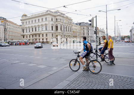 Männliche Radfahrer und weibliche Siffer warten auf rotes Licht, Wien, Österreich Stockfoto