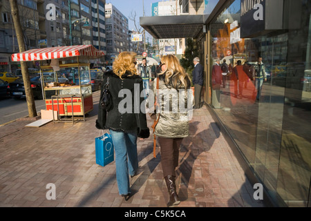 Zwei junge Frauen, zum Einkaufen zu Fuß auf dem Bürgersteig und miteinander zu reden, in Nisantasi, Istanbul, Türkei Stockfoto