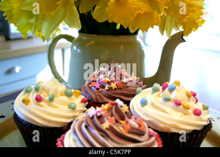 Cupcakes und Teekanne mit Narzissen Stockfoto