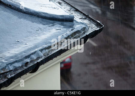 Nasses Wetter. Schwere Regen auf dem Dach und in die Regenrinne mit einer Straße im Hintergrund, Nottinghamshire, England, Großbritannien Stockfoto
