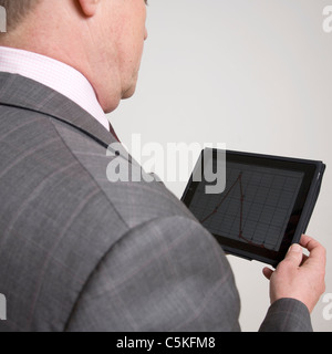 Mann hält und Grafik auf dem Ipad betrachten Stockfoto