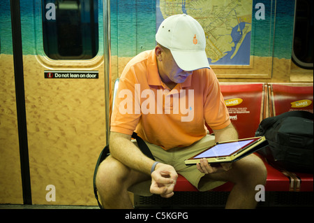 Apple iPad Benutzer liest während seiner u-Bahnfahrt in New York auf Sonntag, 24. Juli 2011 zu sehen. (© Richard B. Levine) Stockfoto