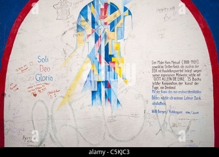 Eines der vielen Gemälde an der Berliner Mauer East Side Gallery, die größte Open-Air-Galerie der Welt. Berlin, Deutschland Stockfoto