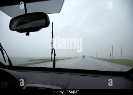 Autofahren auf einzelne Autobahn durch schwere Regen und Überschwemmungen Felder im südlichen Saskatchewan Kanada Stockfoto