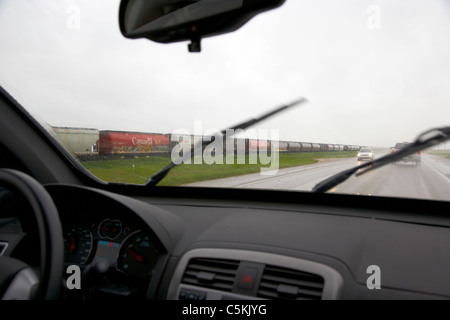 Auto fahren durch schwere Gewitter vorbei Zug im südlichen Saskatchewan Kanada Stockfoto