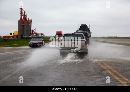 Autos fahren durch schwere Regen und Überschwemmungen Straßen im südlichen Saskatchewan Kanada Stockfoto