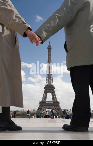 Hände von Ehepaar im Ruhestand (70er Jahre) Rückansicht, Hand in Hand, Eiffelturm im Hintergrund, Paris, Frankreich Stockfoto