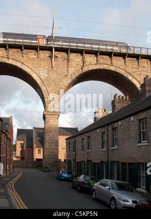 Trainieren Sie, überqueren ein Eisenbahnviadukt über eine kleine Straße von Reihenhäusern, Durham, County Durham, England, UK Stockfoto