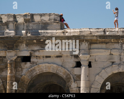 Eine Frau fotografiert ein anderes auf römischen Amphitheater, Ort des Aromaten, Nimes, Frankreich Stockfoto