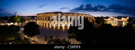 Panorama der Ort des Aromaten mit römischen Amphitheater und dem Rathaus in der Nacht, Nimes, Frankreich Stockfoto