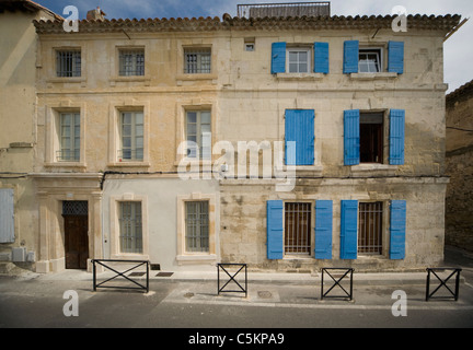 Zwei angrenzende alte Stein 3-geschossige Häuser in Arles, Frankreich, mit blauen Fensterläden an den Fenstern Stockfoto