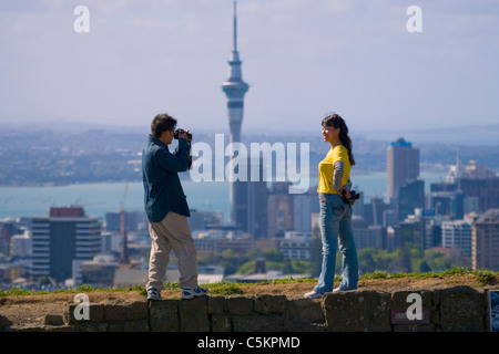 Zwei Touristen auf Mount Eden mit dem Sky Tower im Hintergrund, Auckland, New Zealand, der Mann, ein Bild von der Frau. Stockfoto