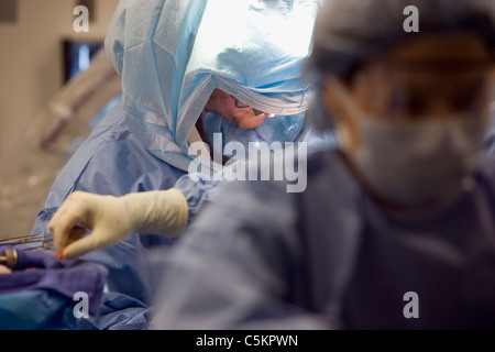 Arzt orthopädische Chirurgie bei Patienten durchführen.  Arzt und Krankenschwester in der orthopädischen Chirurgie. Arzt in Steri Anzug durchführen Stockfoto