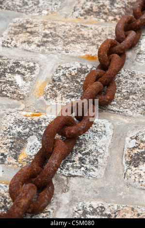 Große / große und rostenden Metall Eisen Kettenglieder auf Granit Pflastersteine - kornischer Fischerhafen. VEREINIGTES KÖNIGREICH. Stockfoto