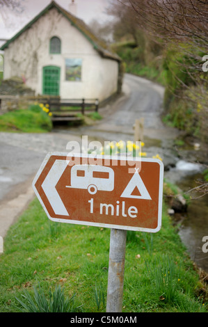 Ein Schild für Camping 1 Meile im Dorf Winsford auf Exmoor, Großbritannien. Stockfoto