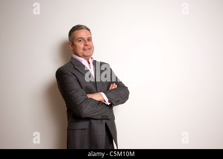 Geschäftsmann mit verschränkten Armen lächelnd Stockfoto