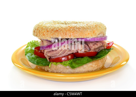 ein Bagel garniert mit Thunfisch, Zwiebeln und Tomaten Stockfoto