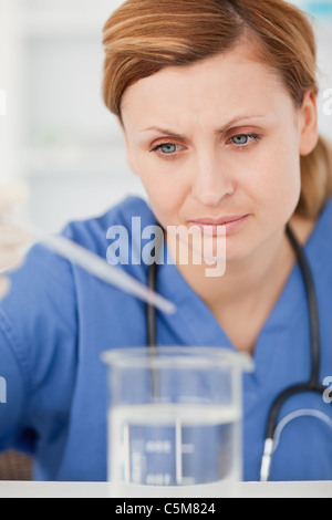 Konzentrierte Vorbereitung ein Experiment mit einer Pipette und einen Becher Wissenschaftler Stockfoto