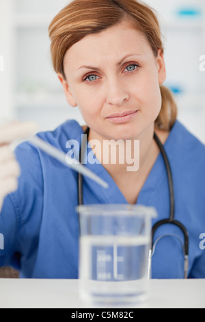 Wissenschaftlerin Vorbereitung ein Experiment mit einer Pipette und einen Becher Stockfoto