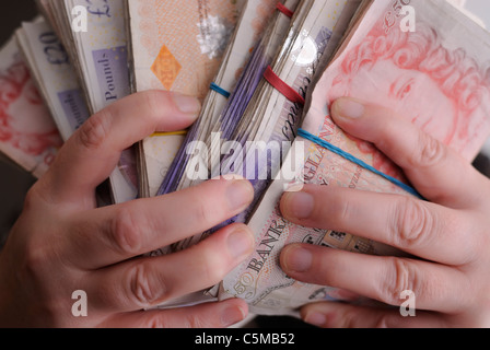 Nahaufnahme Foto Hände greifen oder umklammert Trauben von Banknoten. Stockfoto