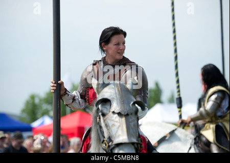 Eine attraktive Frau Reiter verkleidet als Ritter als Teil eines Ritterturniere Display Teams hält einen Turnier Pol auf dem Pferd sitzen. Stockfoto