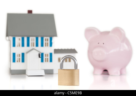 Haus mit Vorhängeschloss und Piggy Bank gesperrt Stockfoto