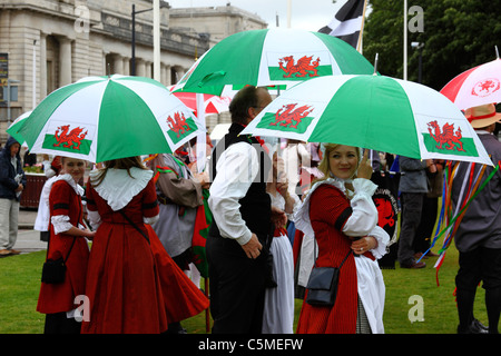 Tänzer in traditionellen Kleid Unterschlupf unter Sonnenschirmen am Mittsommer-Tag, Cathays Park, Cardiff, South Glamorgan, Wales, UK Stockfoto