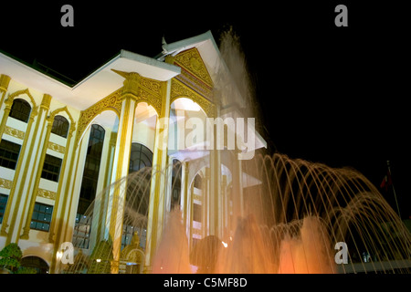 Eine Fontäne sprüht Wasser in der Nacht in The National Hall of Culture in Vientiane, Laos. Stockfoto