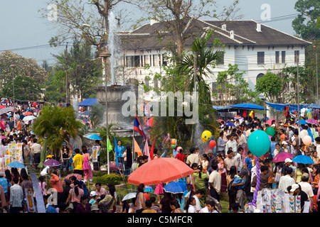Menschen werden auf einer Straße wartet eine Lao Neujahr Parade zu beginnen auf einer Stadtstraße in Luang Prabang, Laos gesammelt. Stockfoto