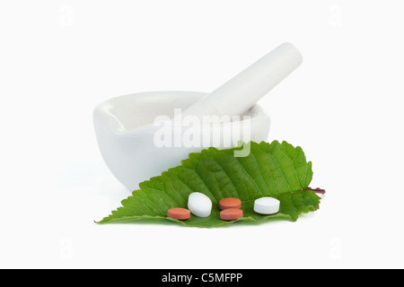 Mörser und Stößel mit Pillen auf einem Blatt Stockfoto