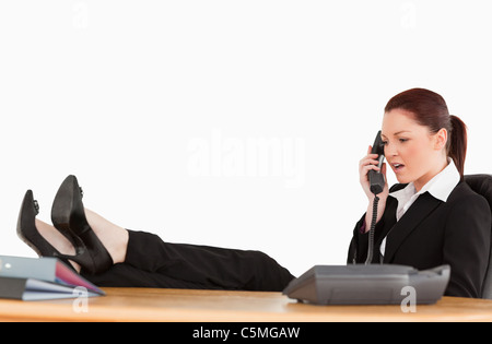 Unglückliche Geschäftsfrau auf dem Telefon in ihrem Büro Stockfoto