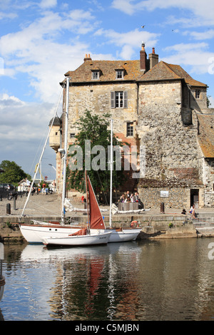 Hölzerne Segelboote mit La Lieutenance im Hintergrund in den Hafen von Honfleur, Normandie, Frankreich Stockfoto